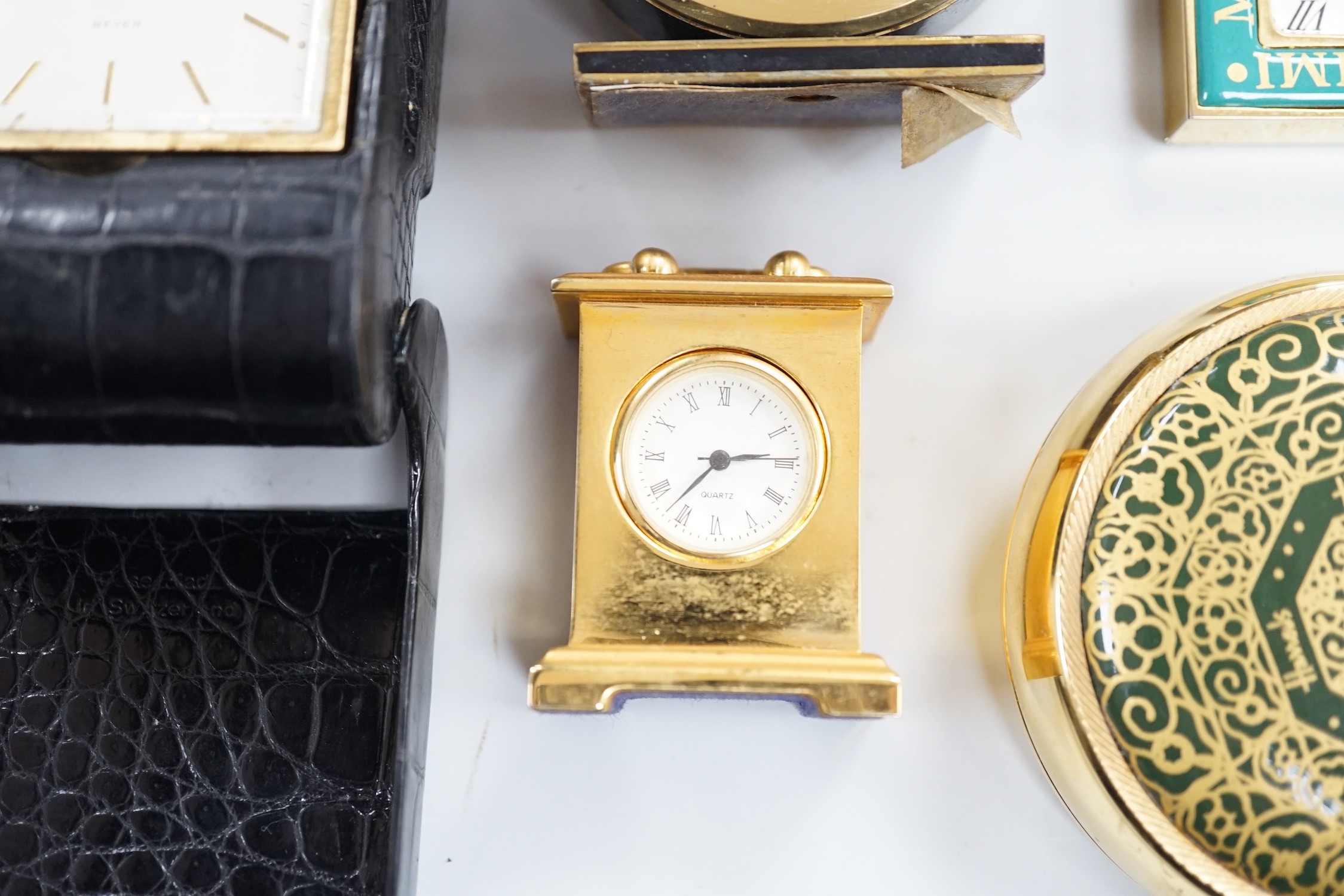 A Halcyon Days Harrods paperweight, a Halcyon Days timepiece and three other timepieces